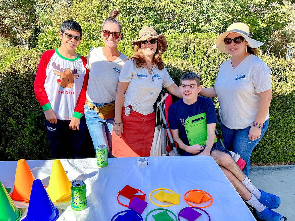 Friendly staff surrounds a student with disabilities